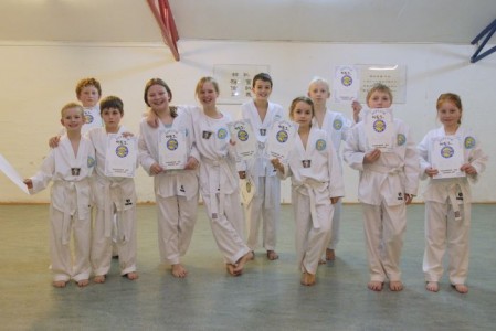 10 glade taekwondo-børn med diplomer